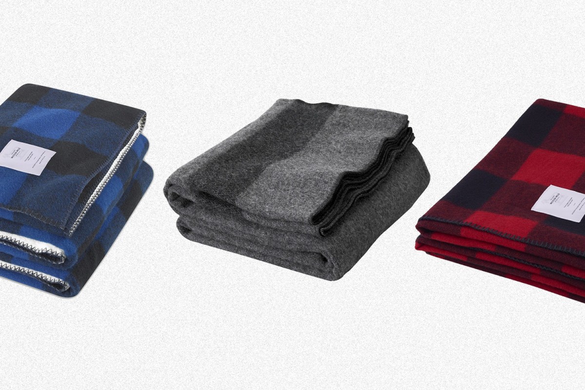 Three Woolrich blankets in blue buffalo check, grey and red buffalo check