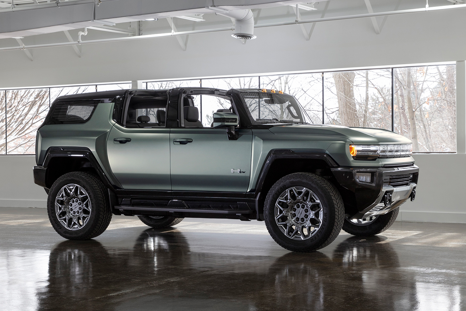 A green electric Hummer SUV from GMC sitting in an empty showroom