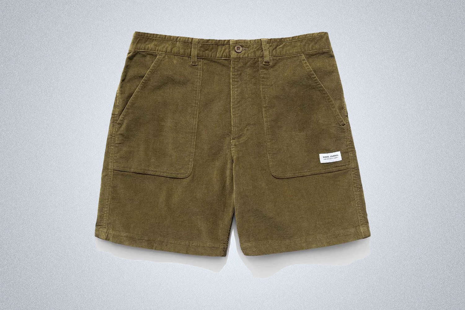 a pair of olvie green Banks Journal corduroy shorts on a grey background