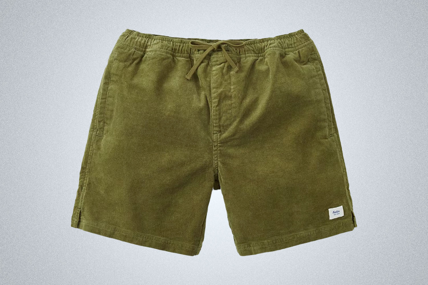 a pair of green Katin corduroy shorts on a grey background