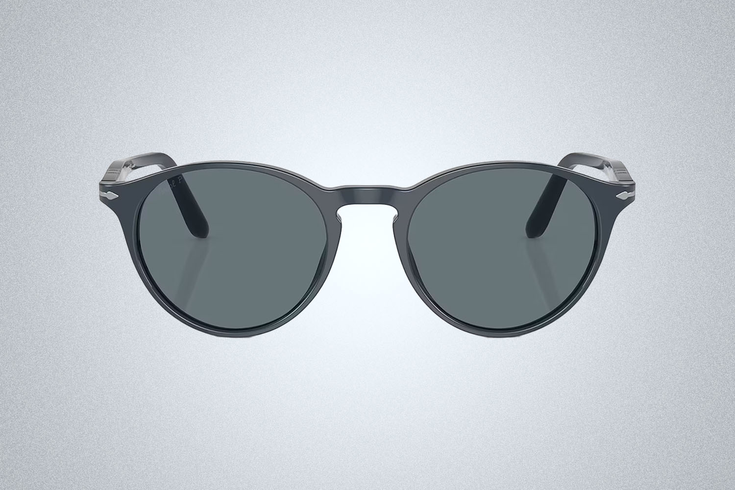 a pair of Persol sunglasses on a grey background