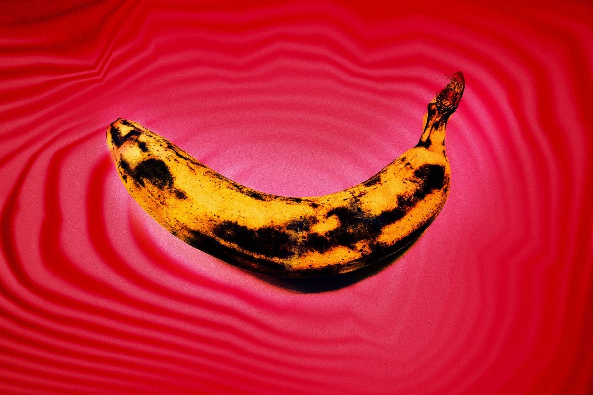 bruised banana on red background