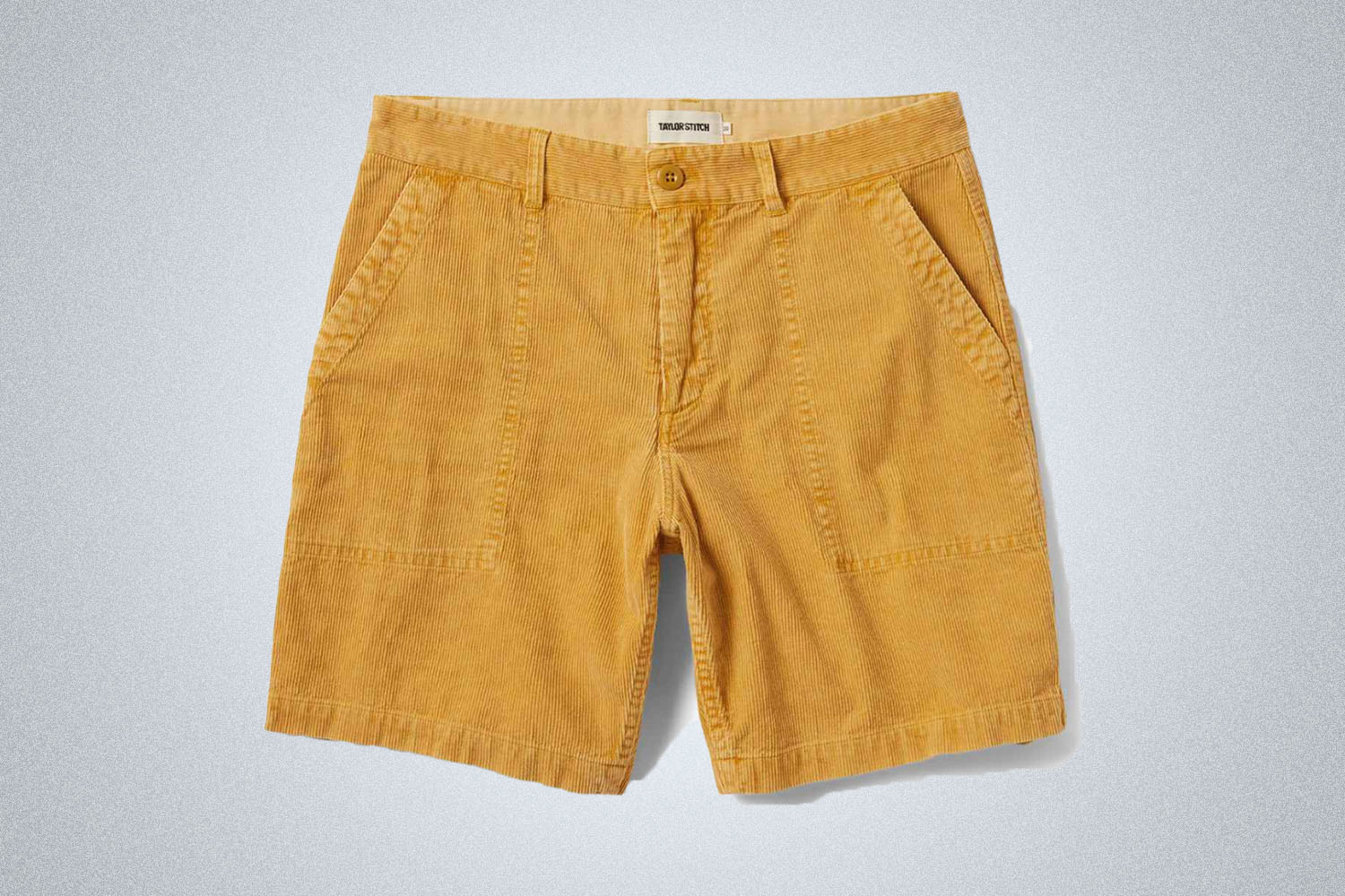 a pair of gold Taylor Stitch corduroy shorts on a grey background