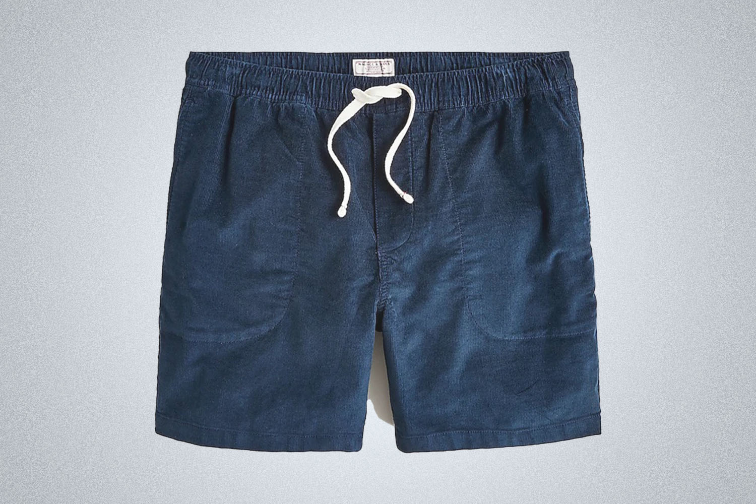 a pair of Wallace and Barnes blue corduroy shorts on a grey background