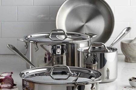 A seven-piece All-Clad Stainless Steel Cookware Set sitting on the kitchen counter