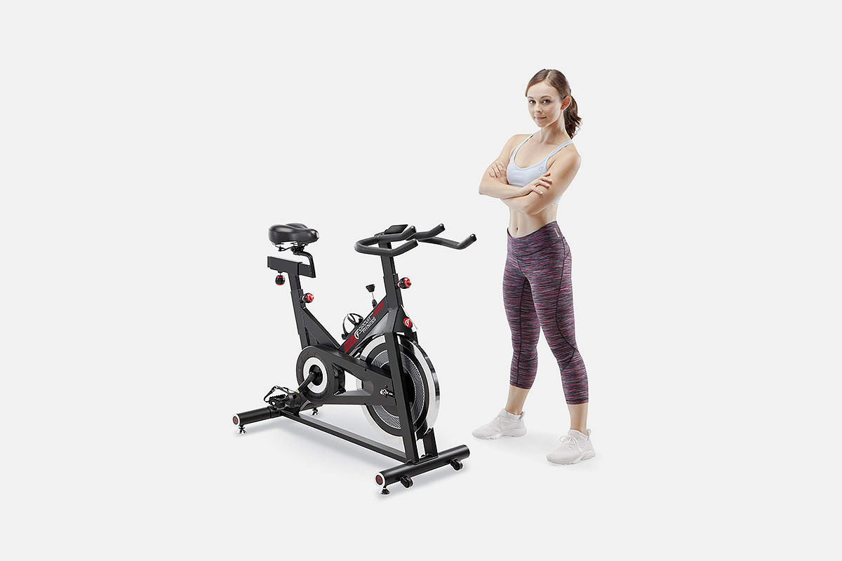 A woman in fitness gear next to a Circuit Fitness bike, which is on sale at Woot