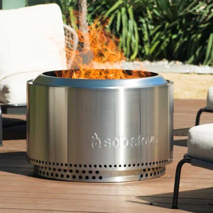 a Solo Stove fire pit in use on a back patio. The Solo Stove bundles are now on sale.