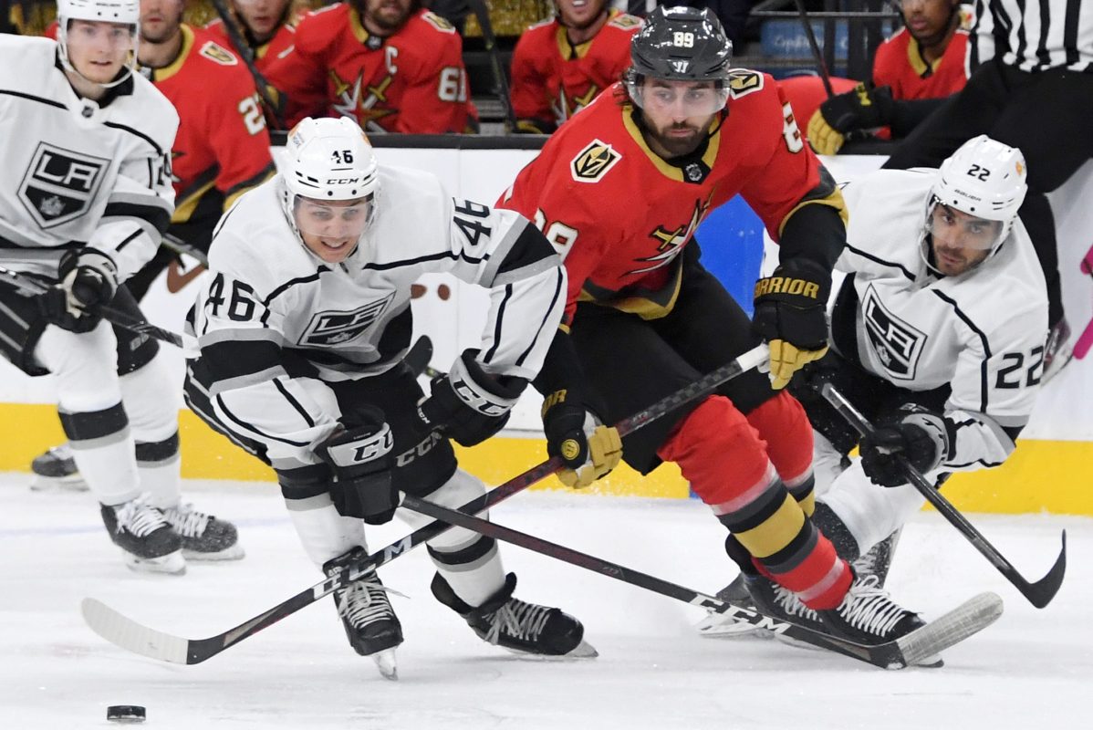 NHL players from the Los Angeles Kings and Vegas Golden Knights fight for the puck