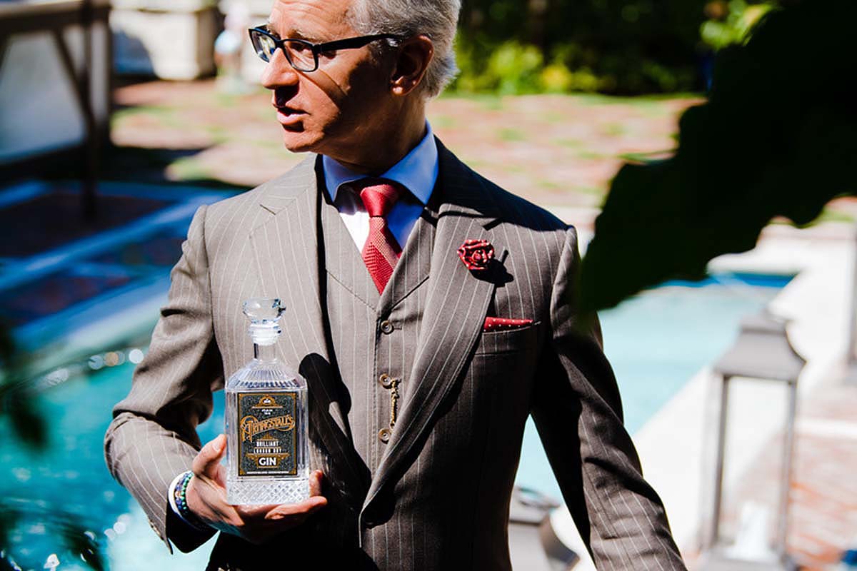 Paul Feig near a pool with a bottle of Artingstall's, his own gin brand