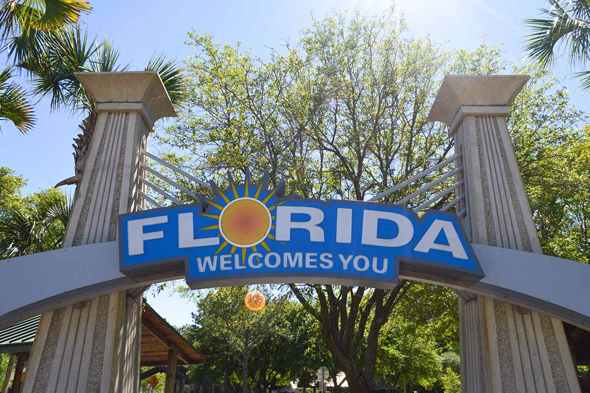 a sign saying "Florida Welcomes You." The state had several areas in Tripadvisor's most popular summer destinations list.