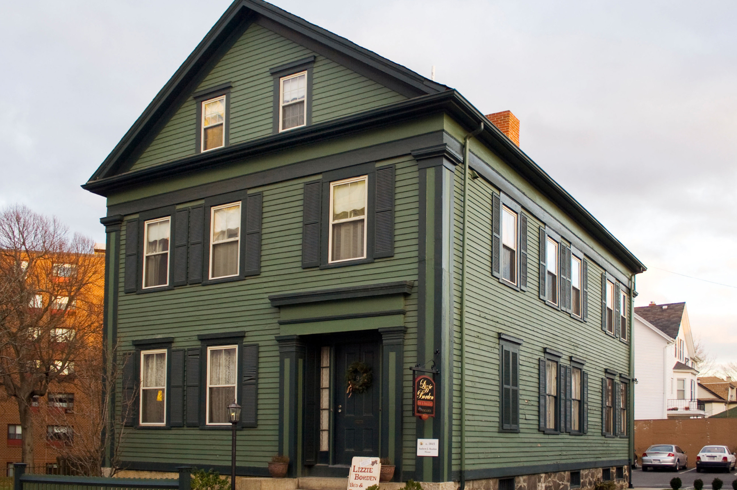 Exterior shot of dark green Greek Revival style home in Fall River, Massachusetts