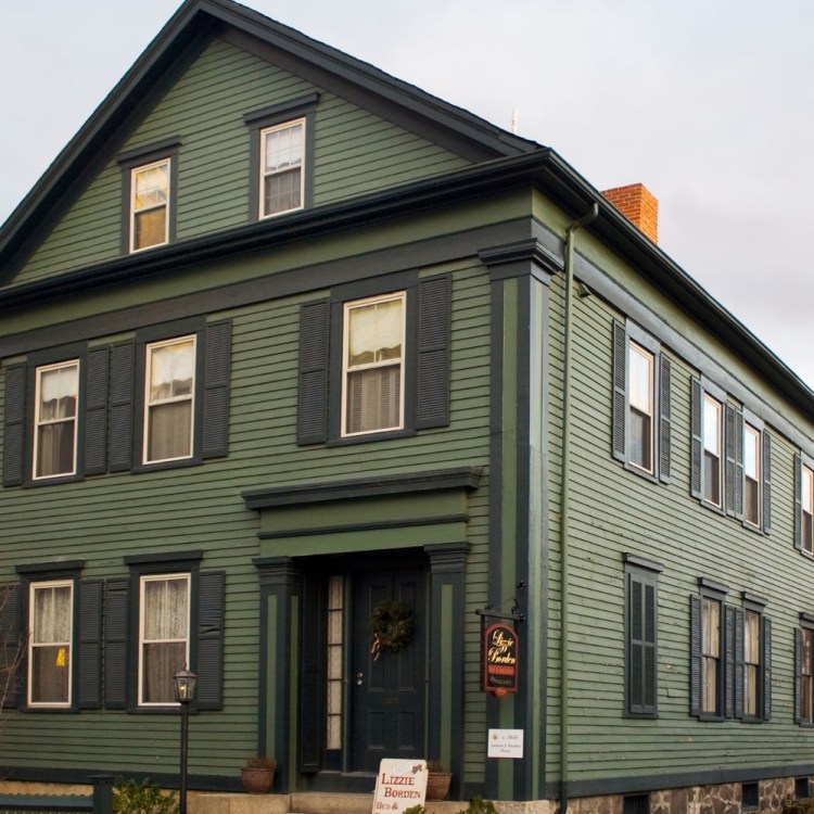 Exterior shot of dark green Greek Revival style home in Fall River, Massachusetts