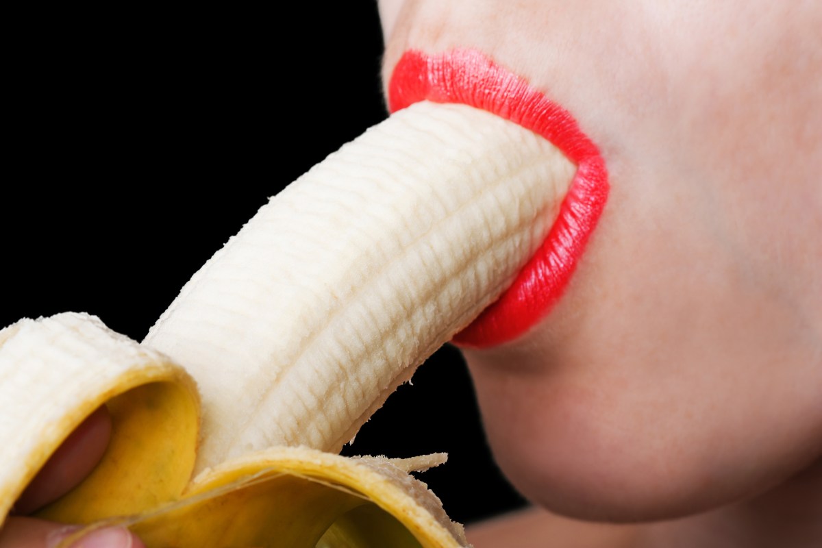 close-up of woman sucking on a banana