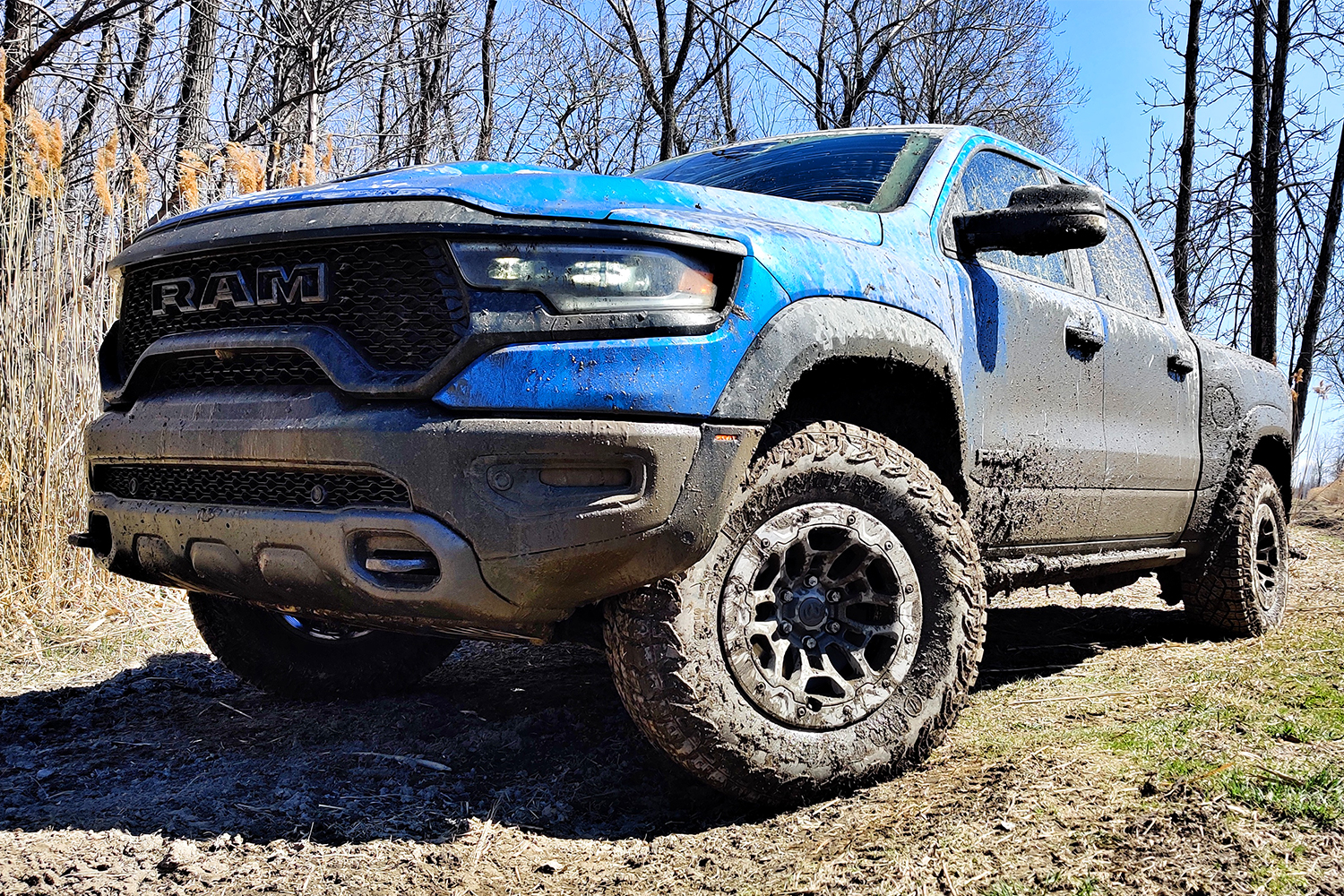 A blue 2021 Ram 1500 TRX off-road pickup truck after driving through the mud
