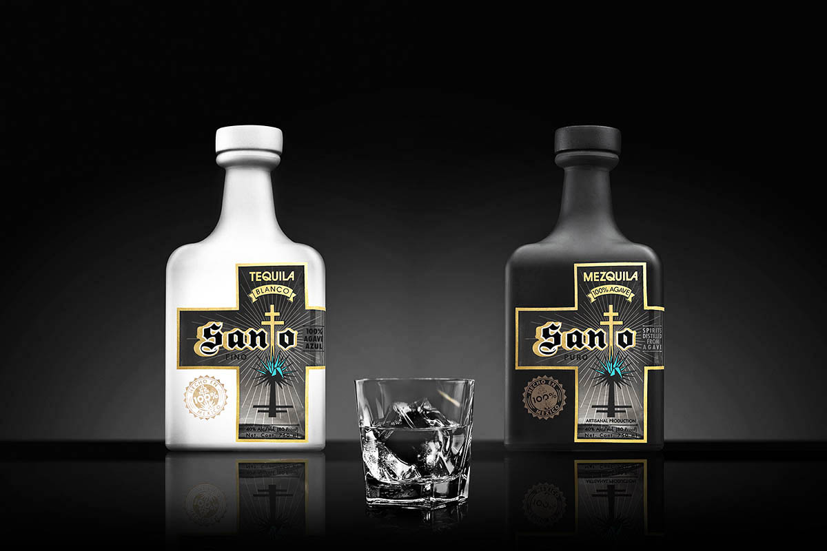 a bottle of Santo's blanco tequila, a glass with ice and a bottle of Santo's Mezquila