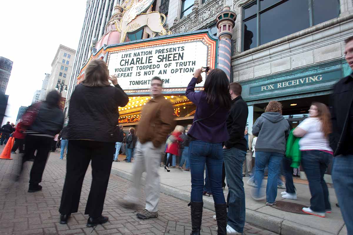 Charlie Sheen fans pose for pictures in front of the Fox Theatre in Detroit, Michigan on April 2, 2011 to start his show "Violent Torpedo of Truth/Defeat is Not an Option."