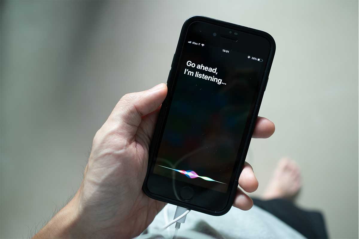 Siri, Apple's voice-activated digital assistant, tells iPhone user to ask her by showing the text "Go ahead, I'm listening" on the display.