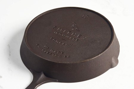 A Smithey No. 12 cast iron skillet flipped upside down on a table