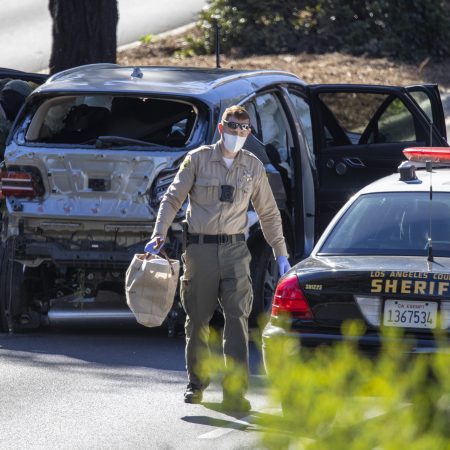 Los Angeles County Sherrif deputies with the vehicle that golf legend Tiger Woods crashed