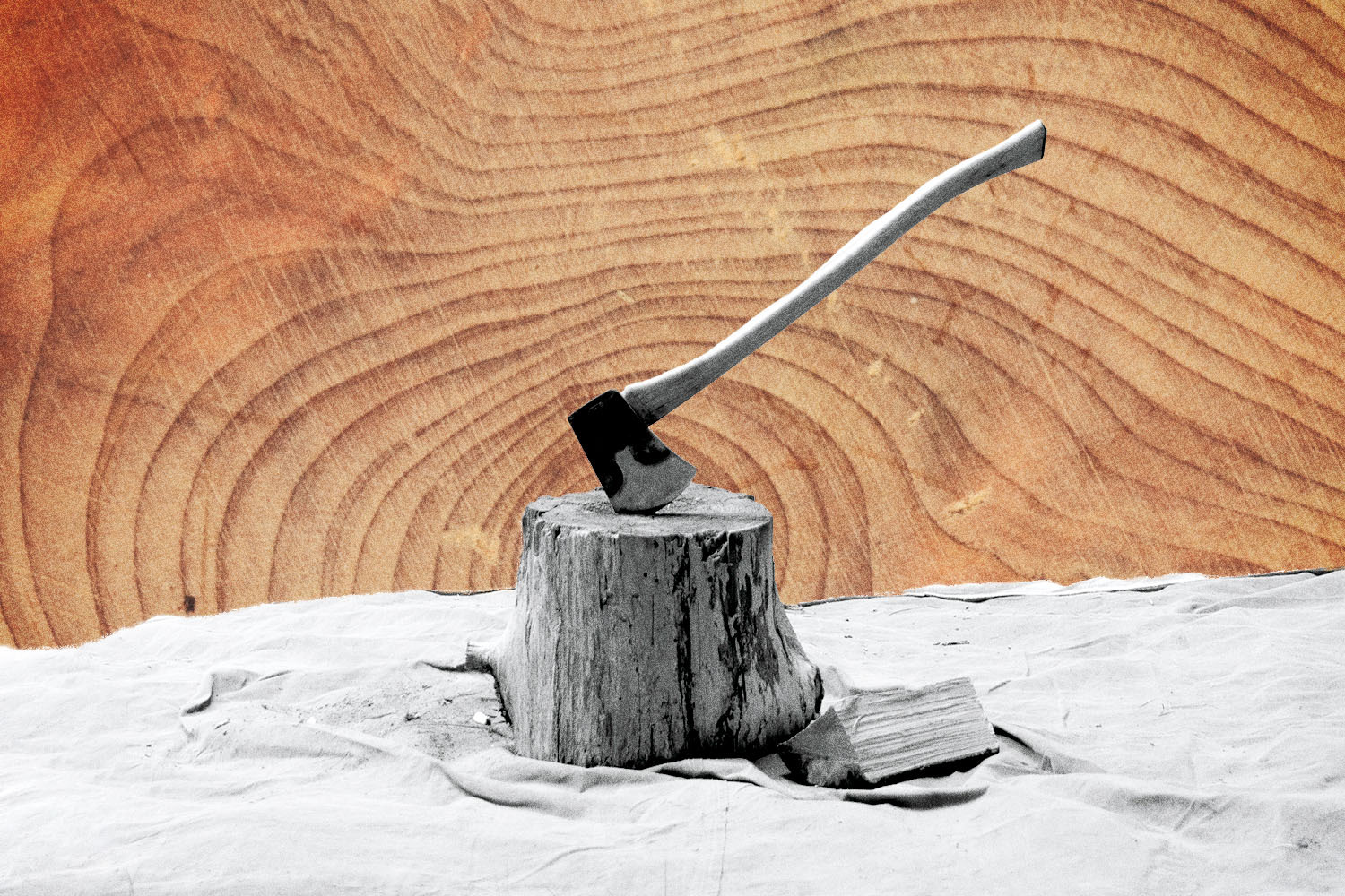 A black and white photo of an axe sticking in a wood stump with a wood-grain background