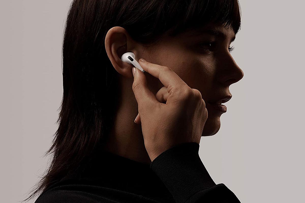 Silhouette of a woman putting in the left earbud of Apple's AirPods Pro. The earbuds are now on sale at Woot.