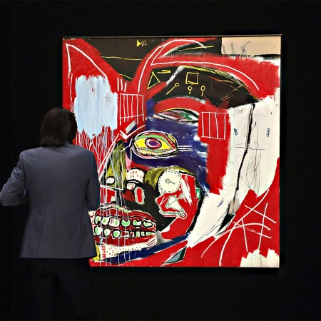 A person standing in front of “In This Case,” a painting by Jean-Michel Basquiat