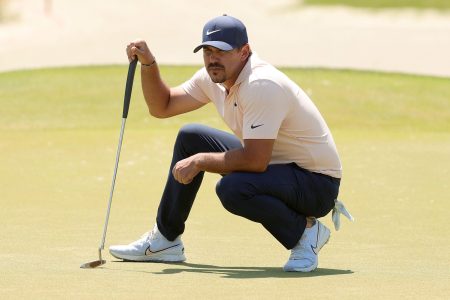Brooks Koepka lines up a putt
