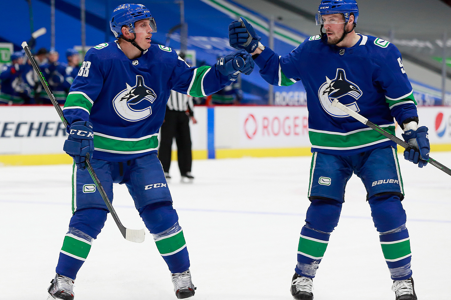 Nate Schmidt #88 of the Vancouver Canucks is congratulated by teammate J.T. Miller #9 after scoring during their NHL game against the Edmonton Oilers at Rogers Arena on May 4, 2021