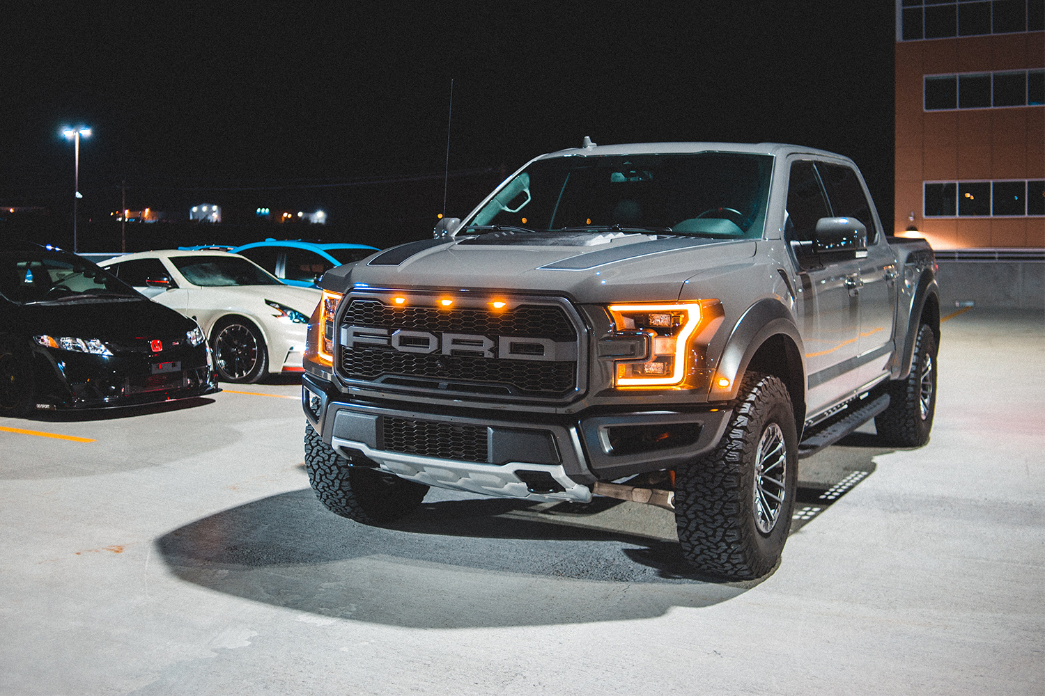 A giant Ford pickup truck sitting next to a line of cars
