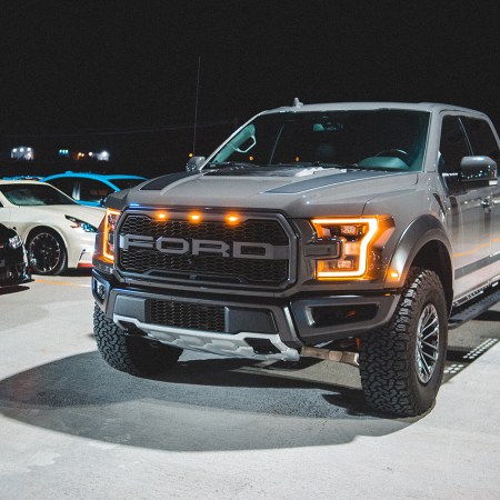 A giant Ford pickup truck sitting next to a line of cars
