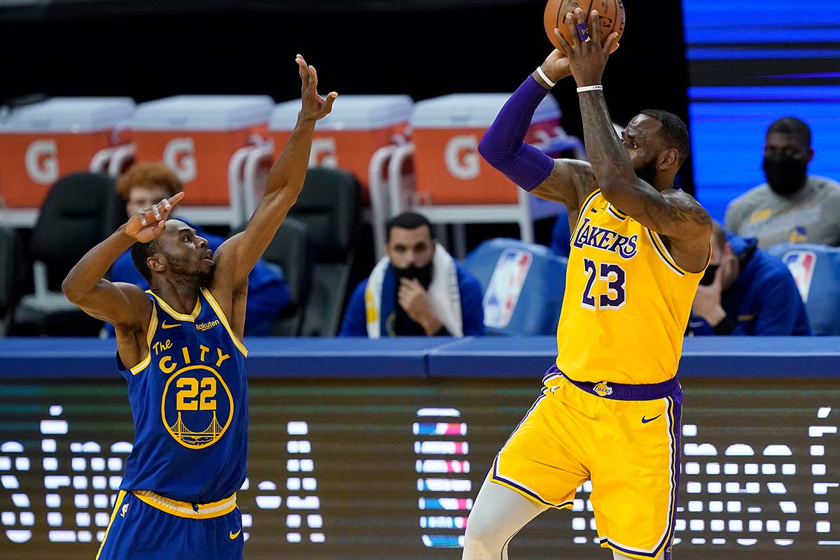 LeBron James #23 of the Los Angeles Lakers shoots over Andrew Wiggins #22 of the Golden State Warriors during the second half of an NBA basketball game at Chase Center on March 15, 2021 in San Francisco, California