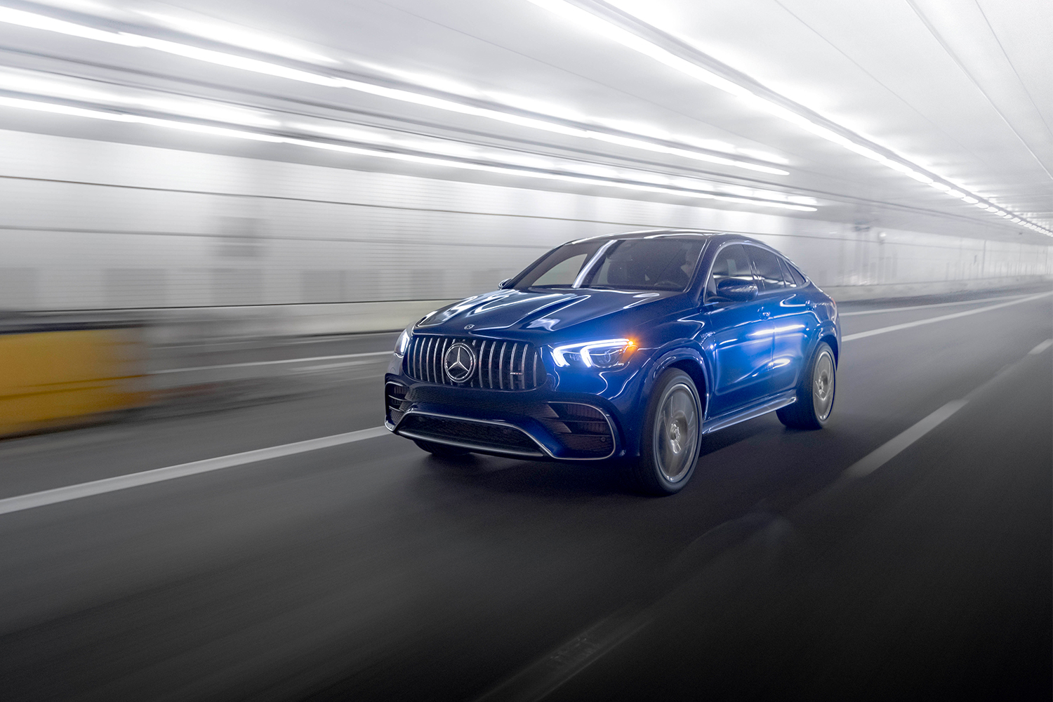 A blue Mercedes-AMG GLE 63 S Coupe driving through a lit tunnel