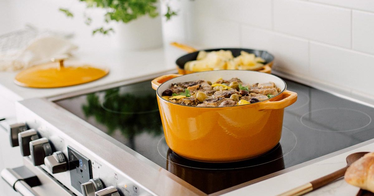 The Milo Dutch oven and skillet, in dijon yellow, sitting on a stove. We tested and reviewed the cookware.