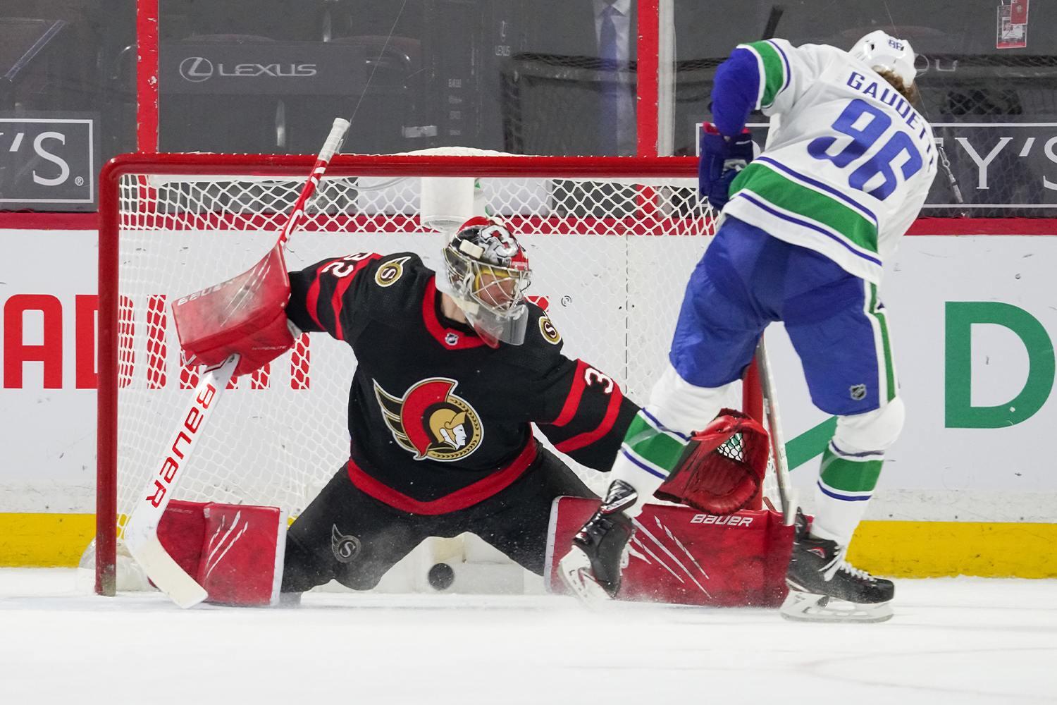 Adam Gaudette #96 of the Vancouver Canucks scores the shootout winning goal against Filip Gustavsson #32 of the Ottawa Senators at Canadian Tire Centre on March 17, 2021