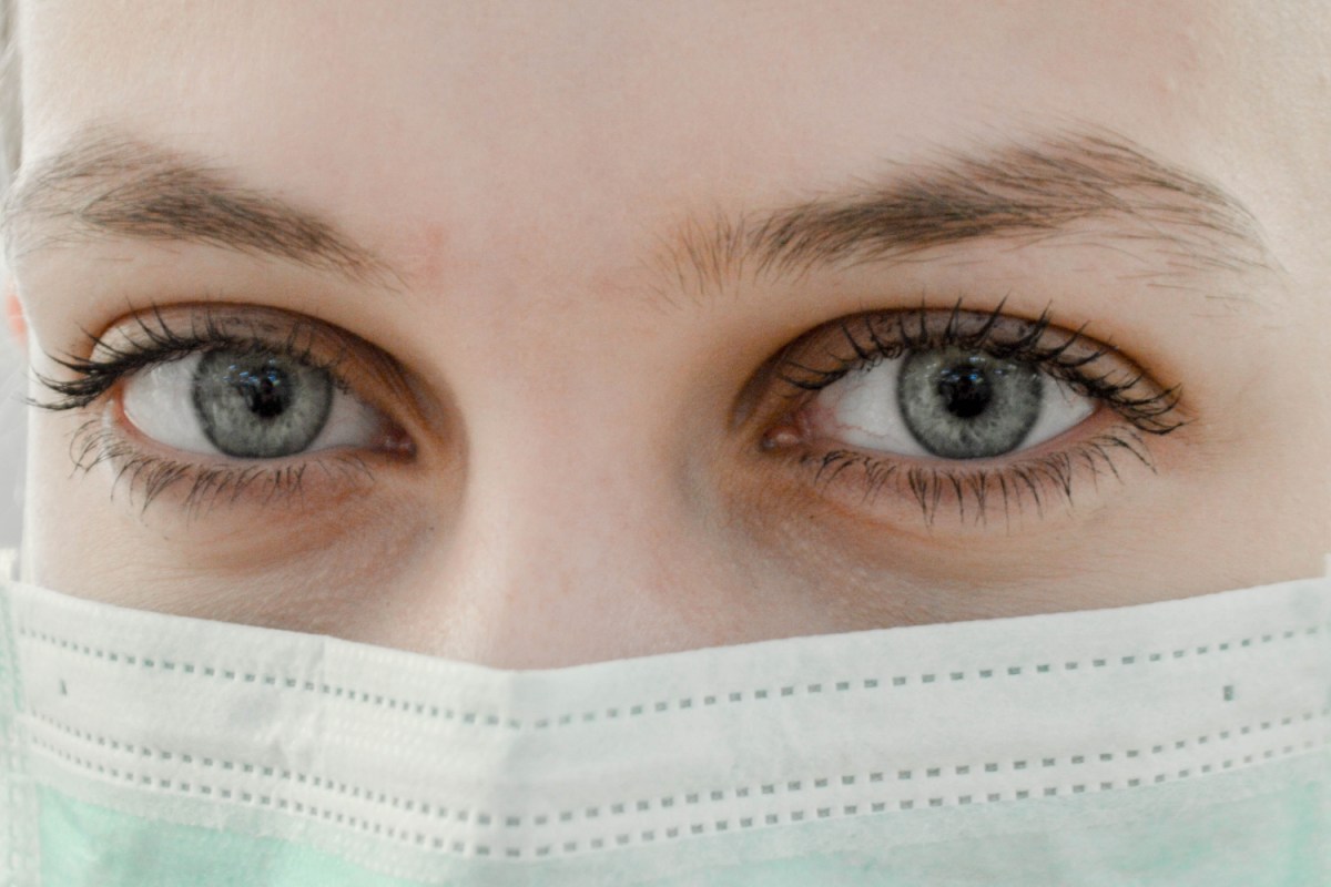 A closeup photo of a woman's eyes over her face mask