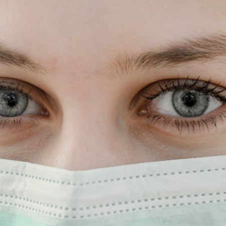 A closeup photo of a woman's eyes over her face mask