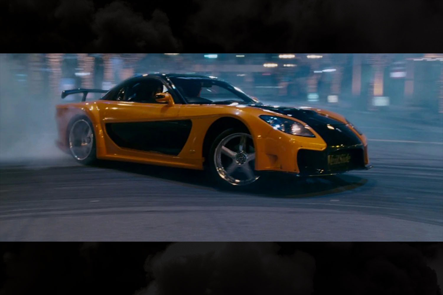 The orange and black 1997 Mazda RX-7 Veilside driven by Han in The Fast and the Furious: Tokyo Drift
