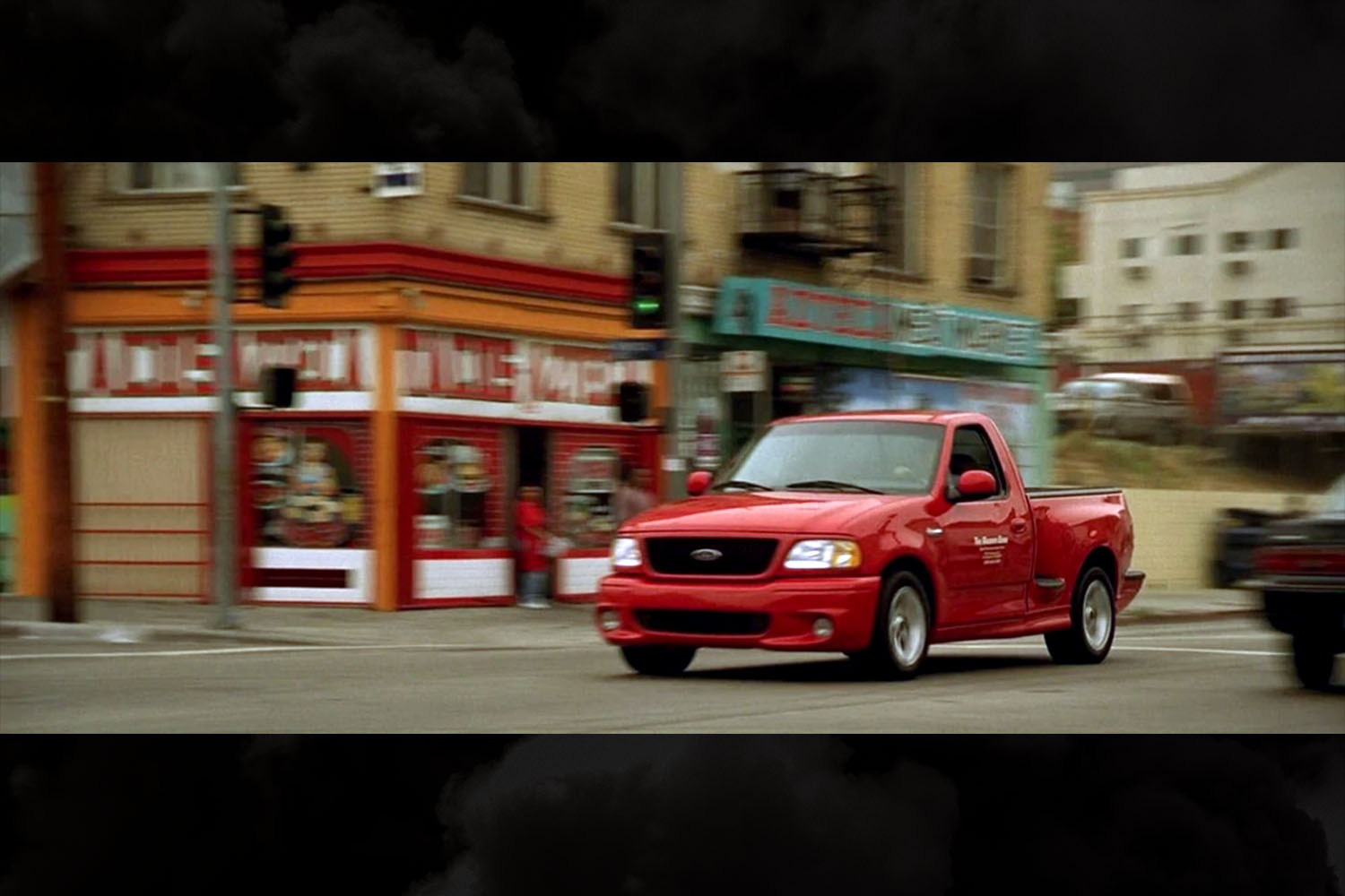 A red Ford F-150 SVT Lightning pickup truck in a scene from the original Fast and Furious movie