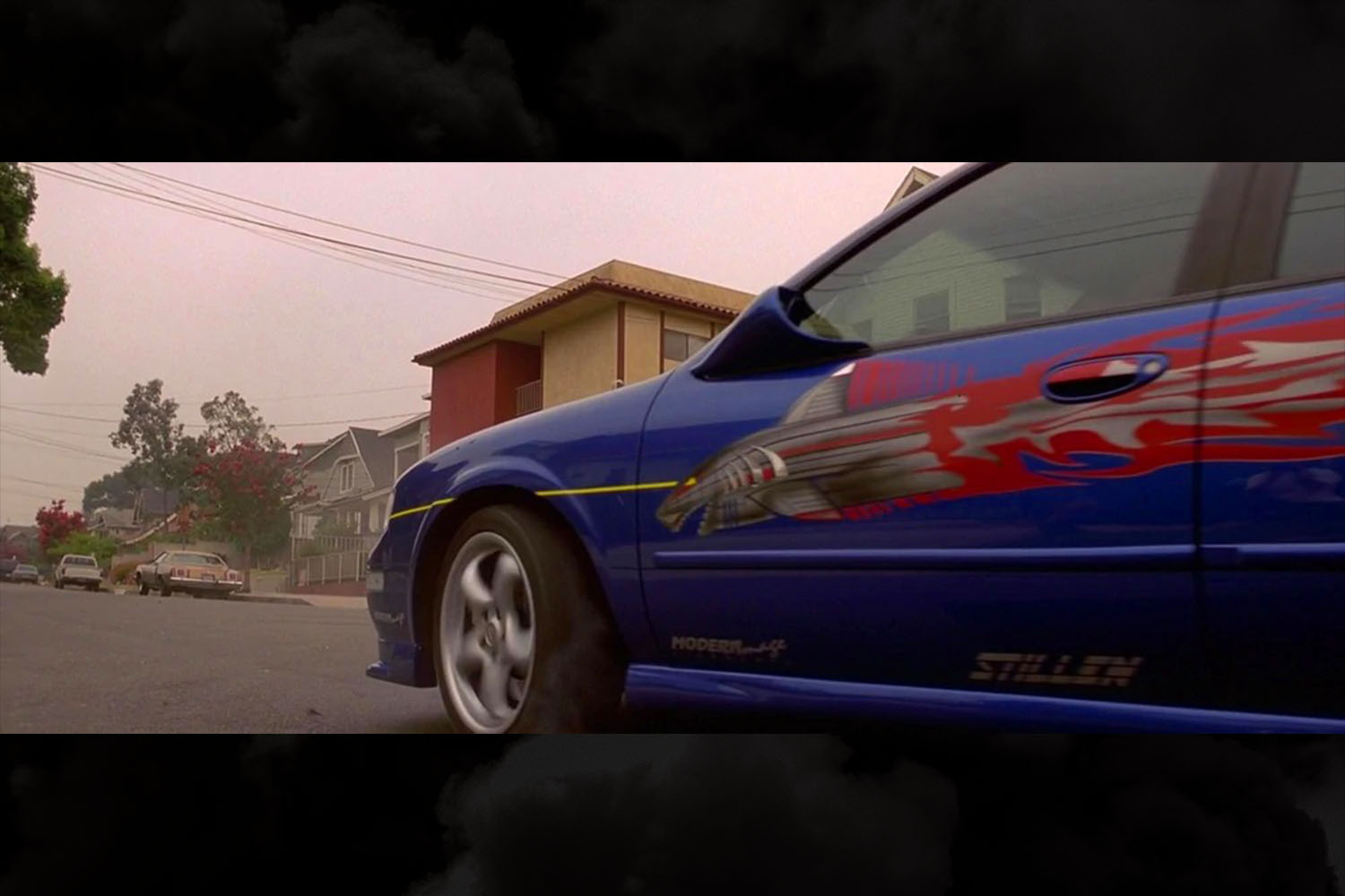 The shark torpedo graphics on the side of Vince's blue 1999 Nissan Maxima in the original The Fast and the Furious