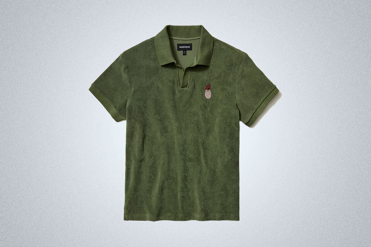a green terry polo from Bonobos on a grey background