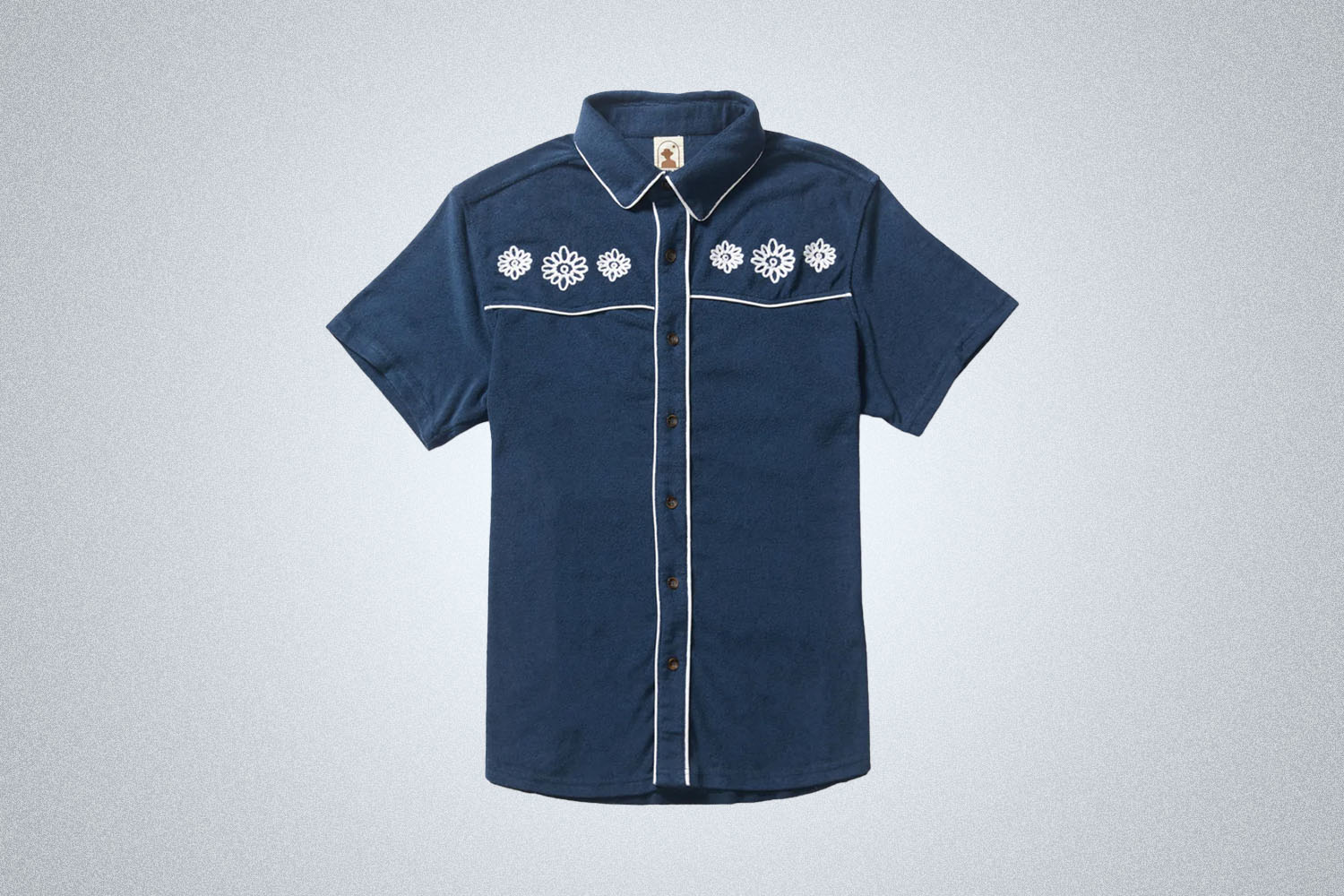 a blue patterned terry polo from Dandy Del Mar on a grey background