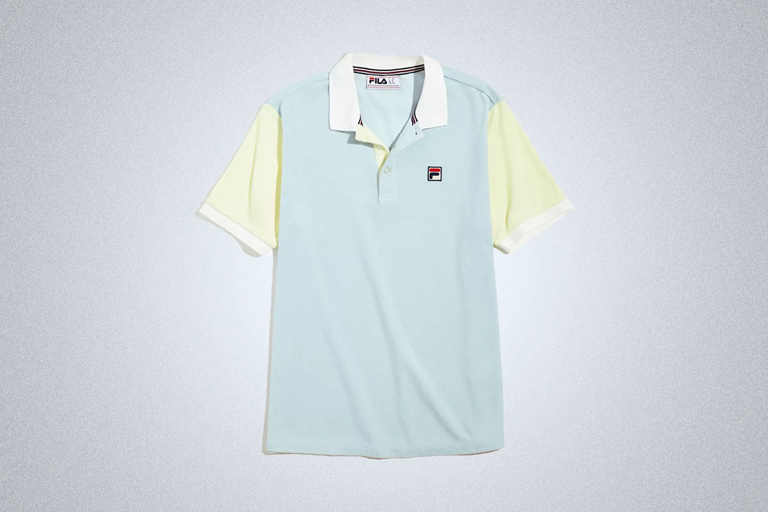A light blue and yellow color-blocked terry polo from FILA on a grey background