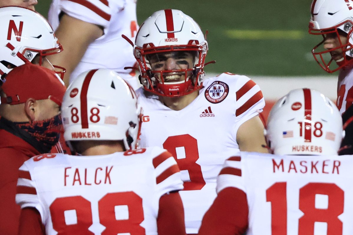 Nebraska Cornhuskers football players in red and white uniforms on the field. The school will soon help the players cash in on their name, image and likeness.