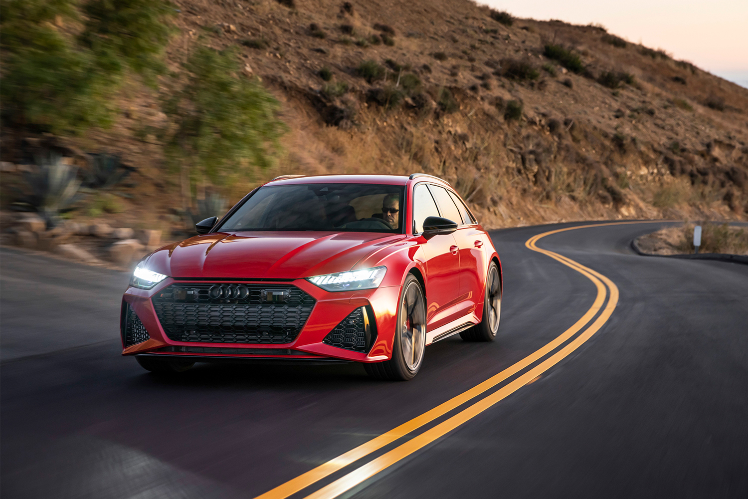 A red 2021 Audi RS 6 Avant driving down a coastal highway. We took the high-powered station wagon for a test drive.