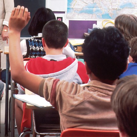 Child raises hand in classroom