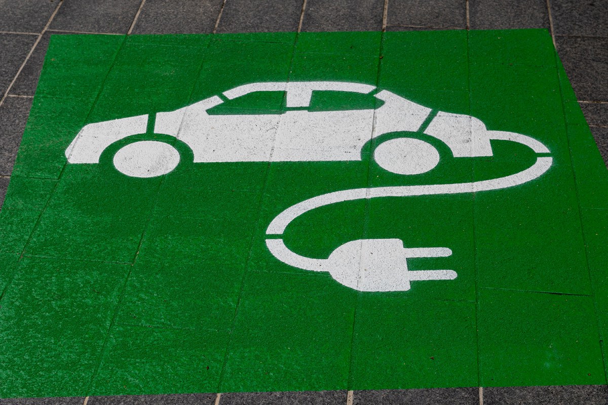 A green and white electric car symbol on a parking space