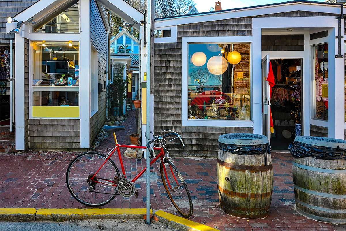 A red bicycle sitting in front of shops in Cape Cod