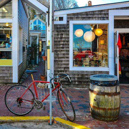 A red bicycle sitting in front of shops in Cape Cod
