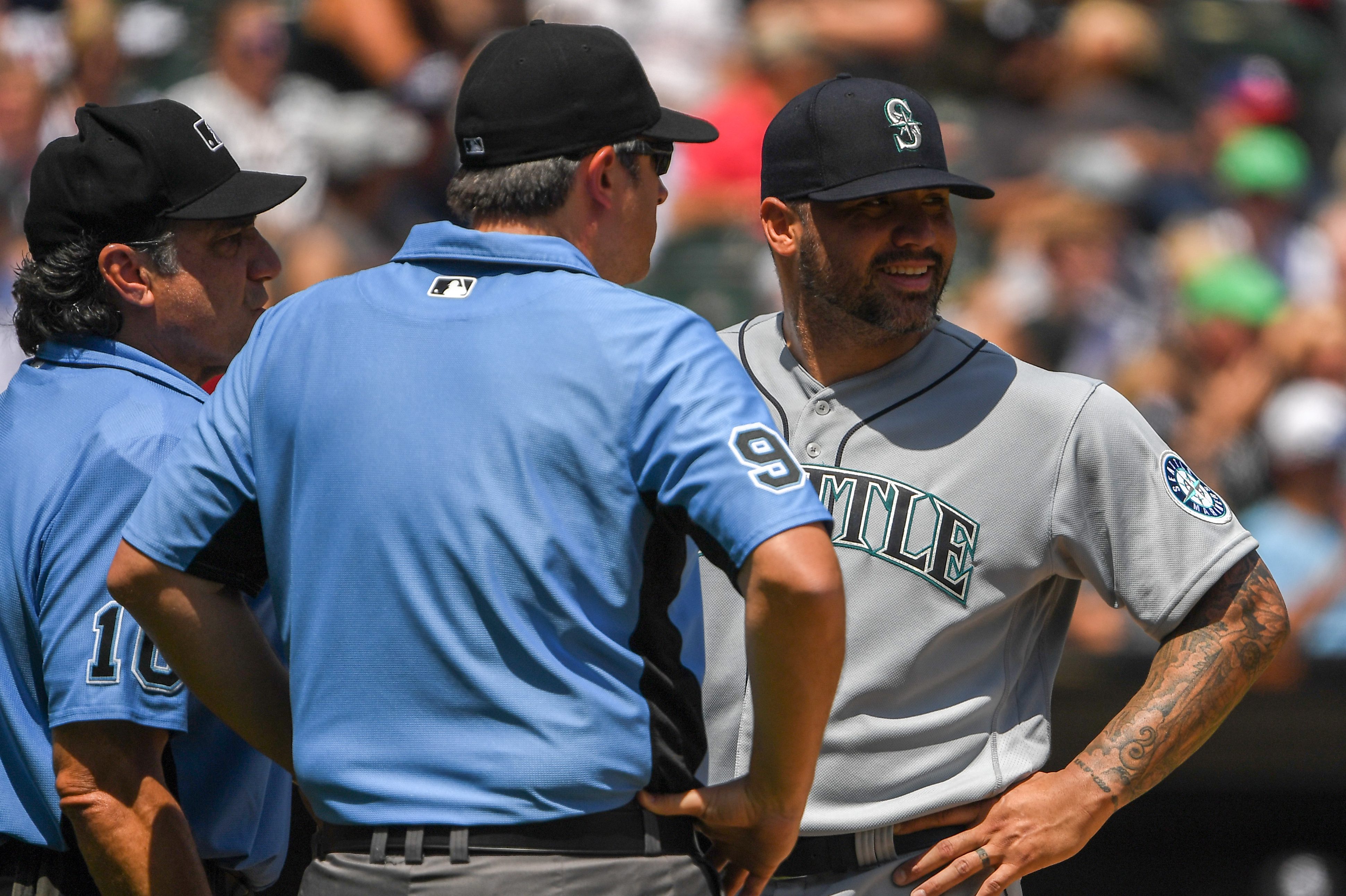 Umpires talk to Hector Santiago of the Seattle Mariners