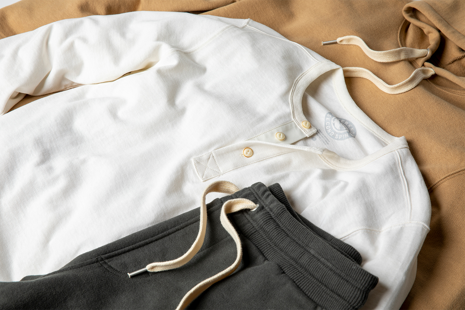 A white henley and grew sweatpants from Outerknown's Second Spin collection